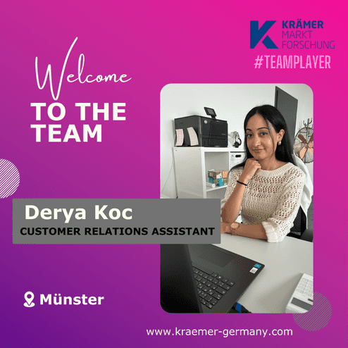 Frau sitzt am Schreibtisch in einem Büro, vor ihr ein Laptop, Hintergrund zeigt Drucker und eine Pflanze.