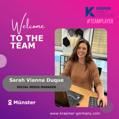 Frau lächelt am Schreibtisch mit Laptop, begrüßt im Team als Social Media Managerin in Münster.